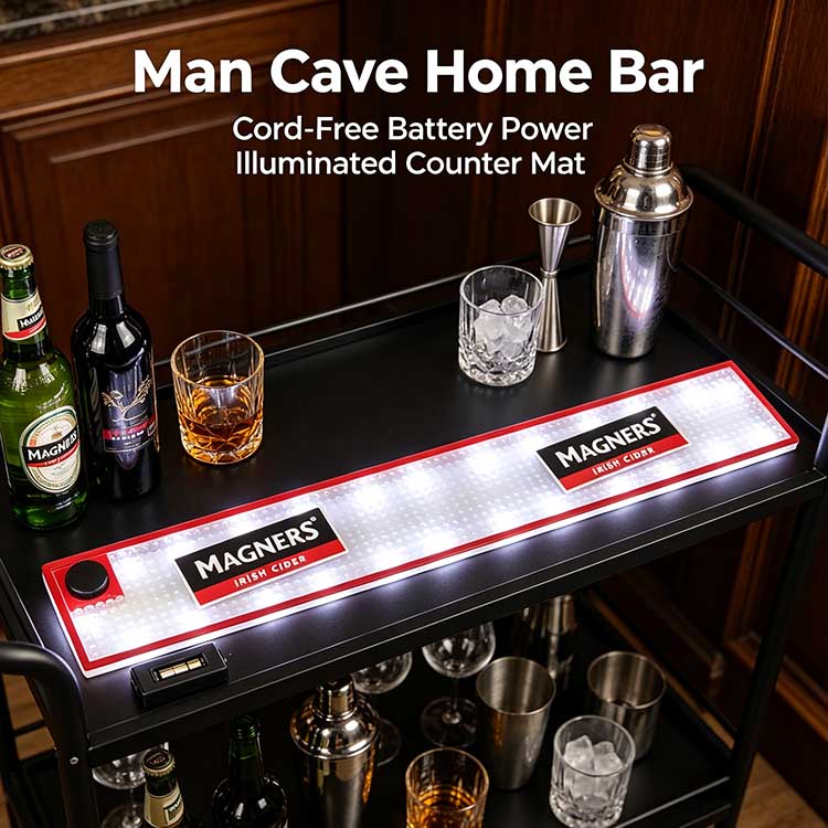 Cord-free battery operated commercial LED bar runner on black metal home cocktail cart, removable battery pack placed beside illuminated Magners bar spill mat with whiskey glasses, bar shaker and cider bottles for portable home bar setup
