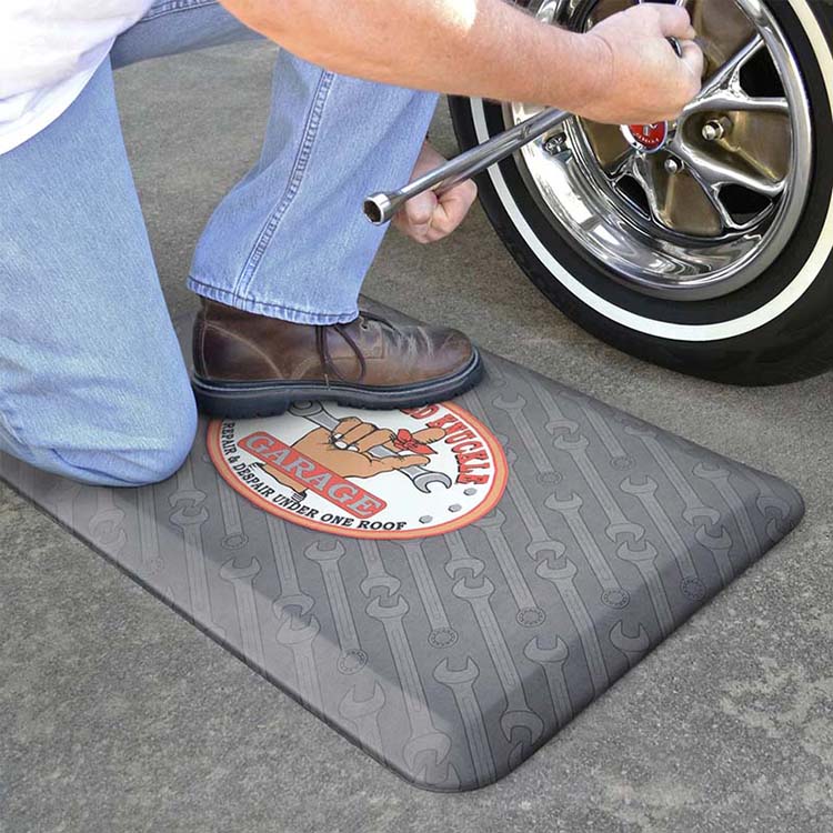 19mm anti-fatigue mat providing knee and leg protection for mechanics during kneeling tire repairs.