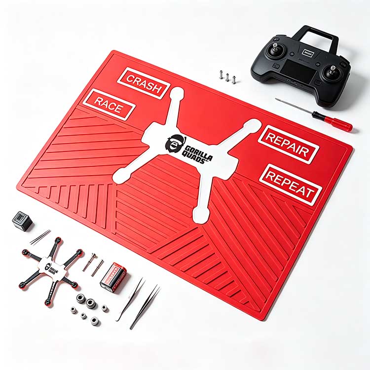 Red non-slip tech mat for FPV drone assembly with remote, battery, and drone parts