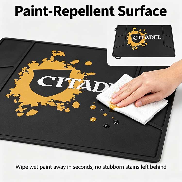 Paint-repellent silicone surface on workshop mat wiping clean after acrylic spills