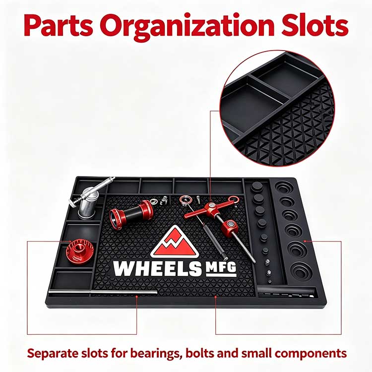 Close-up of the workbench mat showing circular bearing press trays and rectangular slots for organizing bike parts