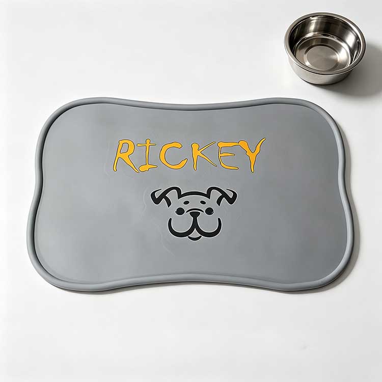 Grey silicone pet placemat with custom embossed name and dog logo design.