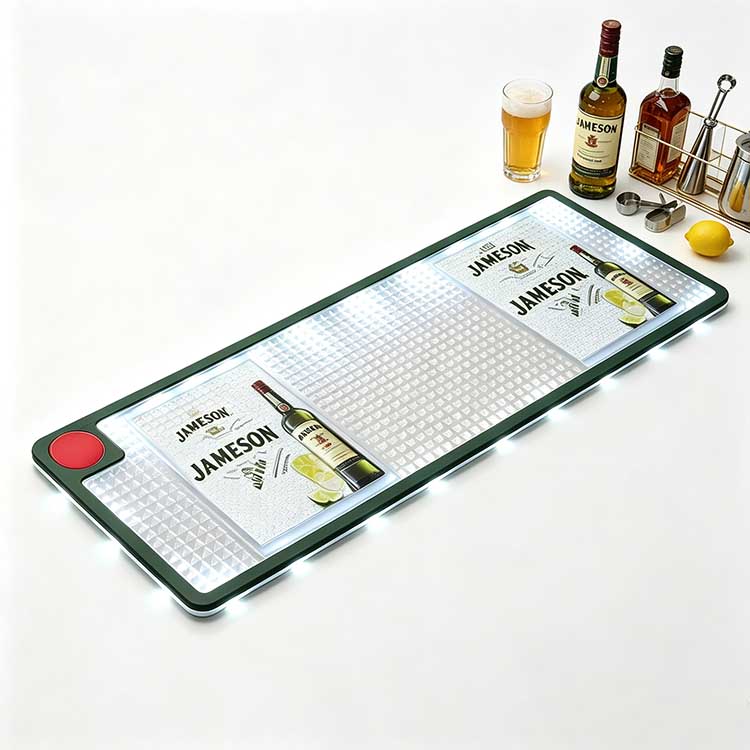 Illuminated Jameson LED Bar Runner Styled with Whiskey & Beer Glassware Studio white background branded LED bar mat with Jameson custom logo, spill-proof illuminated bar drip runner with LED edge lighting, paired with whiskey bottle, beer pint glass, lemon fruit and metal bar jigger for pub & home bar counter decor