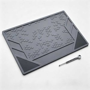 Geometric EDC tool mat with honeycomb grip texture and slanted storage compartments.